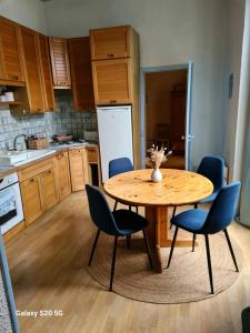 a kitchen with a wooden table and blue chairs at Appartement spacieux 3 chambres in Vannes