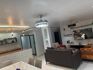 a living room with a couch and a tv at App Résidence Amadou et Coumba in Dakar