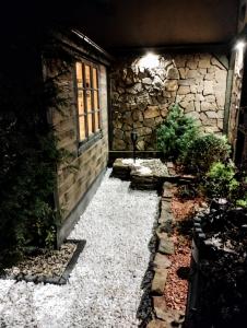 a stone house with a stone walkway and a window at Apartament Dolek in Szczawnica +7 photos