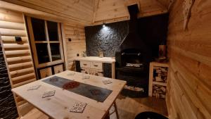 a room with a table and a stove in a cabin at Apartament Dolek in Szczawnica