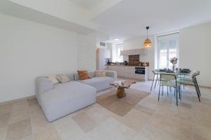 un salon blanc avec un canapé et une table dans l'établissement Appart spacieux 4 chambres , Clim au cœur de Nîmes MaisonCarréeConciergerie, à Nîmes 11 autres photos