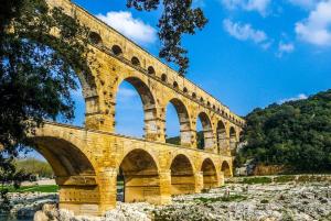 un pont avec des arches sur le côté d'une rivière dans l'établissement Appart spacieux 4 chambres , Clim au cœur de Nîmes MaisonCarréeConciergerie, à Nîmes