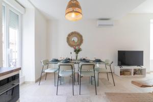 une salle à manger avec une table et des chaises dans l'établissement Appart spacieux 4 chambres , Clim au cœur de Nîmes MaisonCarréeConciergerie, à Nîmes
