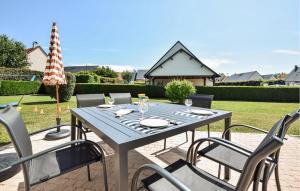a blue table and chairs on a patio at Awesome Home In Blonville-Sur-Mer in Blonville-sur-Mer +24 photos