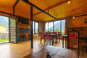 a dining room with a table and some windows at Kazbegi Cottages in Kazbegi