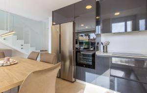 eine Küche mit Holztisch und Edelstahlkühlschrank in der Unterkunft Stunning Home In Cartagena in Cartagena