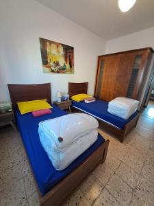 two beds in a room with blue sheets at Une parenthèse magique sur Oran vue inoubliable in Oran