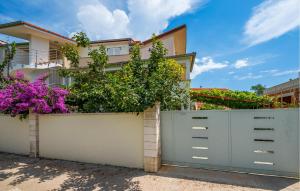 a white fence with plants on it in front of a house at Amazing Apartment In Premantura in Premantura +10 photos