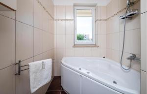 a white bathroom with a tub and a window at Amazing Apartment In Premantura in Premantura