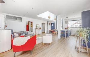 a living room with red chairs and a couch at Maison Moderne Proche Plage in Saint-Coulomb