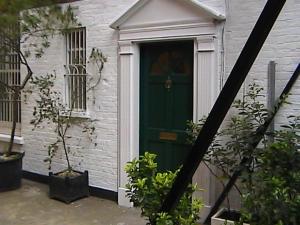 una puerta verde de una casa blanca con en London Kensington & Chelsea 2 Bed Zone 1 Aprt, en Londres