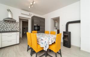 a kitchen and dining room with a table and yellow chairs at 2 Bedroom Lovely Apartment In Rtina in Rtina