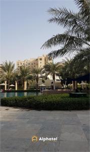 a resort with a swimming pool and palm trees at 2-Bedroom Holiday Home in Remraam Community - Dubai - by Alphatel Vacations in Dubai