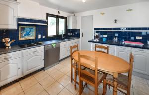 a kitchen with white cabinets and a wooden table at Stunning Home In Uchaux in Uchaux