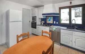a kitchen with white cabinets and a table and a sink at Stunning Home In Uchaux in Uchaux