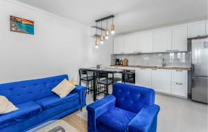 a living room with two blue couches and a kitchen at Amazing Home In Kukuljanovo With Wifi in Kukuljanovo