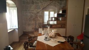 una sala da pranzo con tavolo e parete in pietra di Apartment Koralj a Spalato (Split)