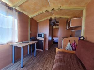 a small room with a bed and a table in a tiny house at stop roulotte in Burthecourt-aux-Chênes