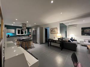 Una sala de estar y una cocina con un sofá y una mesa. en Villa Toscana - 6 Personnes - Full Clim, Piscine et Criques 300m à pied, en Bandol