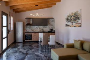 a kitchen and living room with a couch and a table at Paradise Apartments Artemida in Artemida