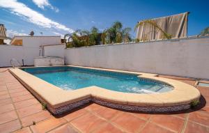 ein Swimmingpool auf einer Terrasse mit einer Mauer in der Unterkunft Nice Home In Chiclana De La Fronter in Chiclana de la Frontera + 24 Fotos