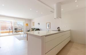 een keuken met witte werkbladen en een woonkamer bij Nice Apartment In Torre De La Horadada in Torre de la Horadada