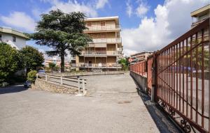 una recinzione di fronte a un edificio con un albero di Nice Apartment In Santo Stefano Al Mare a Santo Stefano al Mare