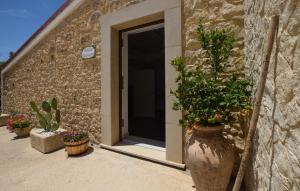 a building with potted plants in front of a door at Tenuta Flaccavento in Chiaramonte Gulfi