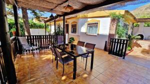 a patio with a table and chairs on a patio at Velez Nazari Cortijo Azud in Vélez de Benaudalla