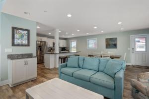 un salon avec un canapé bleu et une cuisine dans l'établissement NH387E Currituck Cottage, à Nags Head