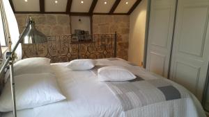 un ampio letto con cuscini bianchi e lampada di Apartment Koralj a Spalato (Split)