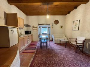 a kitchen with a table and chairs in a room at Τελωνείο Βαμβακούς in Vamvakoú