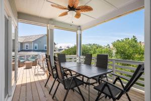 Un patio con una mesa y sillas en una terraza. en WE17 Benders Beach Bungalow, en Nags Head