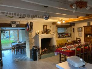 a dining room with a fireplace and a table and chairs at Le Clos Doré Parc in Bains-sur-Oust