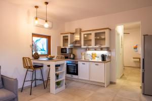 a kitchen with white cabinets and a counter top at Kastri Hill Luxury Villas in Palekastron