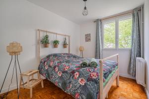 ein Schlafzimmer mit einem Bett und einem Fenster in der Unterkunft Le Jardin Secret in Seyssinet-Pariset