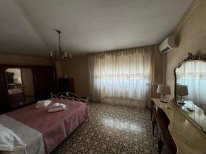una camera da letto con un letto, un comò e uno specchio di La Dimora del Falconiere - Guest House a Sulmona