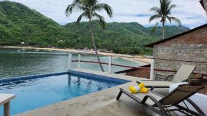 叶莱巴Villas Santa Cecilia Villa Sebas en Yelapa的游泳池边的椅子上坐着一只毛绒玩具