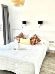a bedroom with a white bed with pillows on it at Casa Gary in Caleta de Caballo