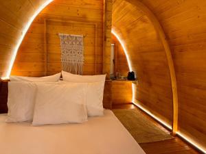 a bed in a wooden room with white pillows at Glicínia Boutique Hotel in Freamunde +119 photos