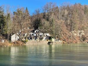 a house sitting on the side of a lake at Gästehaus Altes Fährhaus in Bad Tölz