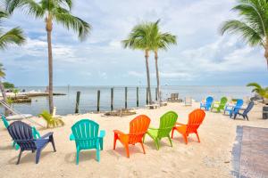 a group of chairs on a beach with palm trees at Aqua Lodges at 47th Street in Marathon