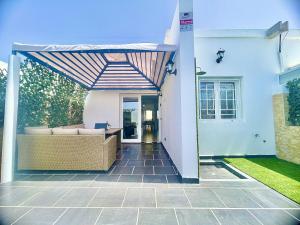 a patio with a couch under awning on a house at Bright Place Bungalow in San Bartolomé