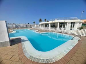 a large blue swimming pool in front of a building at Bright Place Bungalow in San Bartolomé