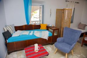 una piccola camera con letto e sedia di Anezo's Exceptional View a Spetses