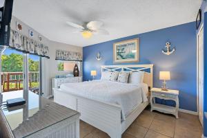 a bedroom with a white bed and a blue wall at Sunrise Resort 209 in St Pete Beach +70 photos