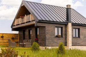 a house with a metal roof and a deck at Adria Nord Chalets in Žabljak