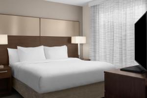 a bedroom with a large white bed and a television at Residence Inn by Marriott Santa Clarita Valencia in Santa Clarita