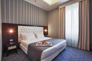 Una habitación de hotel con una cama con una bandeja de comida. en Hotel Naples en Nápoles