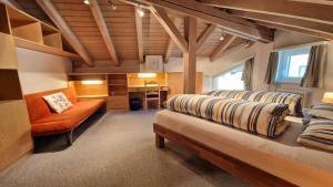 Habitación con cama, sofá y escritorio. en Chesa Bellaval, Haus Leivra 6½-Zimmerwohnung, en Silvaplana